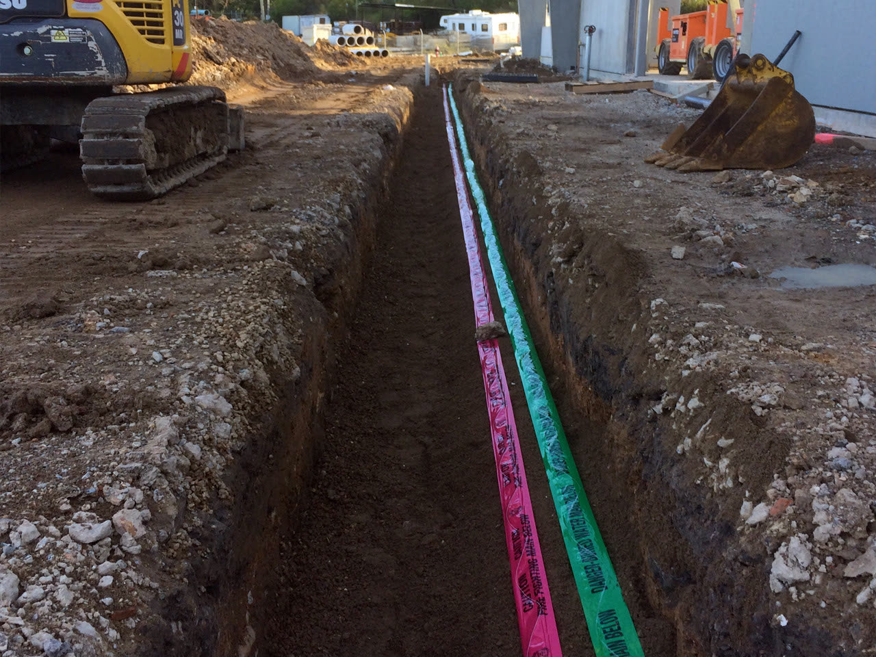 Excavation trench with buried pipes on a Leonay Plumbing construction site