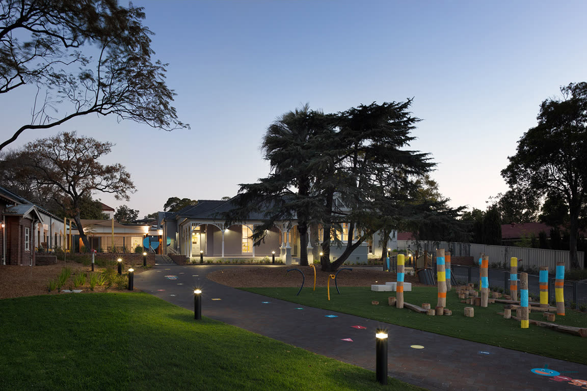 Landscaped play area and school buildings at Meriden School at dusk